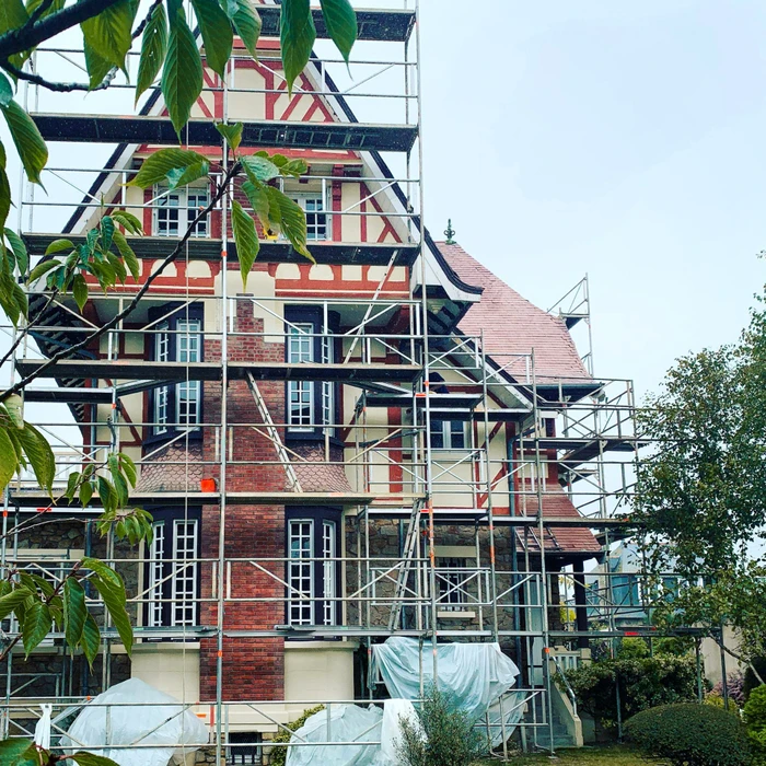 Rénovation d'une villa historique à colombages, briques rouges et toiture en tuiles